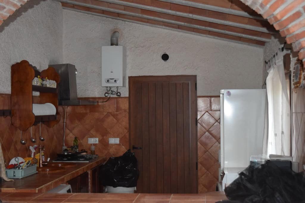 Cave house kitchen with rustic decor, white walls, and wooden accents in Cuevas del Campo, Granada.