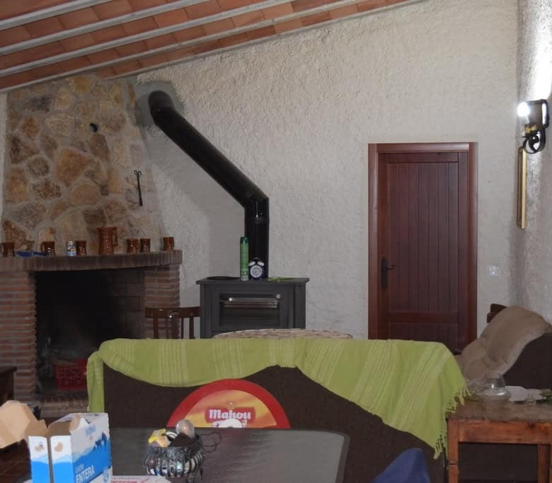 Charming interior of a cave house in Cuevas del Campo, Granada, featuring a fireplace, wooden door,.
