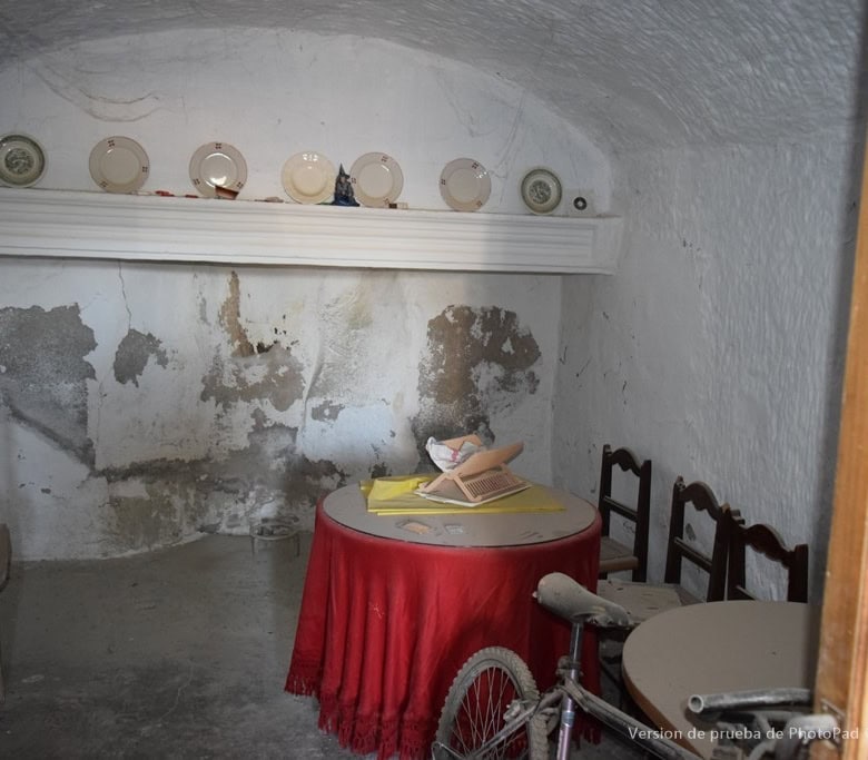 Cave house interior in Cullar, Granada with rustic decor and vintage furniture.