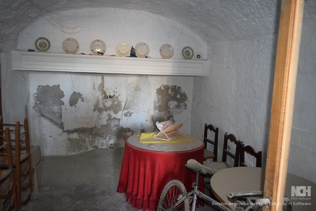 Cave house interior in Cullar, Granada with rustic decor and vintage furniture.