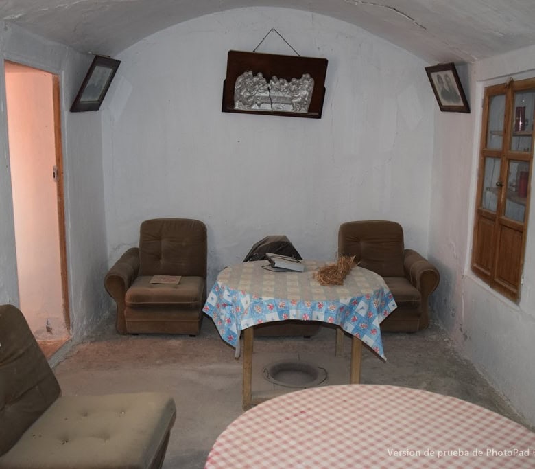 Cozy cave house living room with rustic furniture and traditional decor in Cullar, Granada.