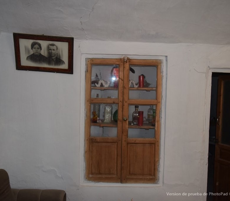 Traditional cave house interior in Cullar, Granada with wooden window and vintage decor.