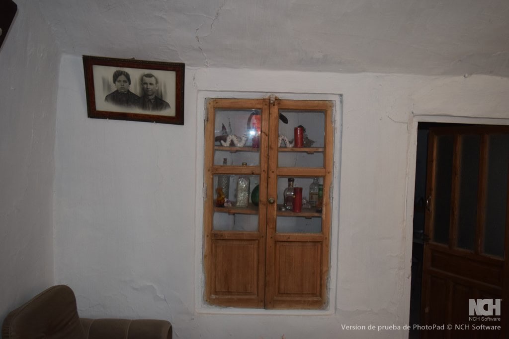 Traditional cave house interior in Cullar, Granada with wooden window and vintage decor.