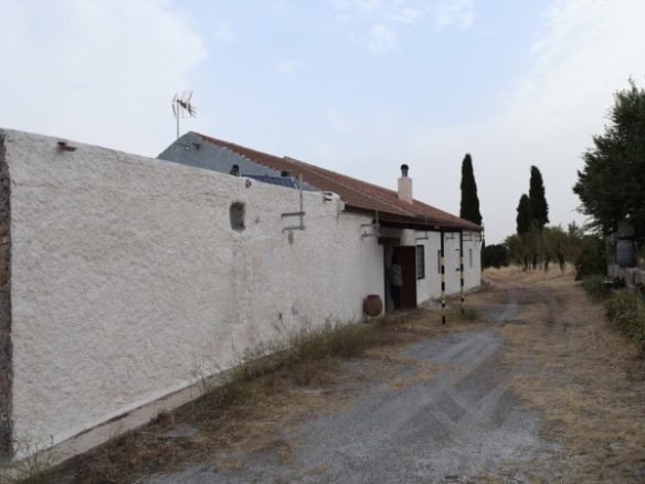 Farmhouse exterior in Baza, Granada with traditional white walls and rural surroundings.