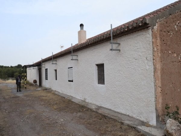 Farmhouse in Baza, Granada with whitewashed walls and rural surroundings.