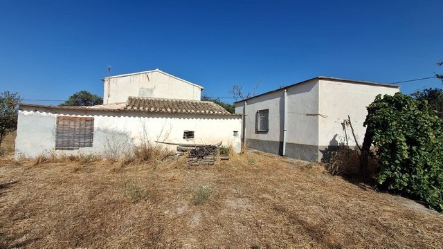 Traditional rural property in Tijola, Almeria with simple white buildings and dry landscape.