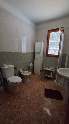 Spacious bathroom in rural Tijola property with toilet, bidet, and sink, featuring natural light fro.