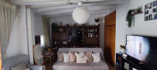 Cozy living room in a town house in Seron, Almeria, featuring a comfortable sofa, wooden shelves, an.