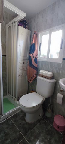 Compact bathroom with shower, toilet, and storage cabinet in Seron, Almeria.