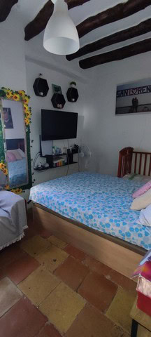 Charming town house interior in Seron, Almeria with rustic wooden ceiling beams and cozy bedroom set.
