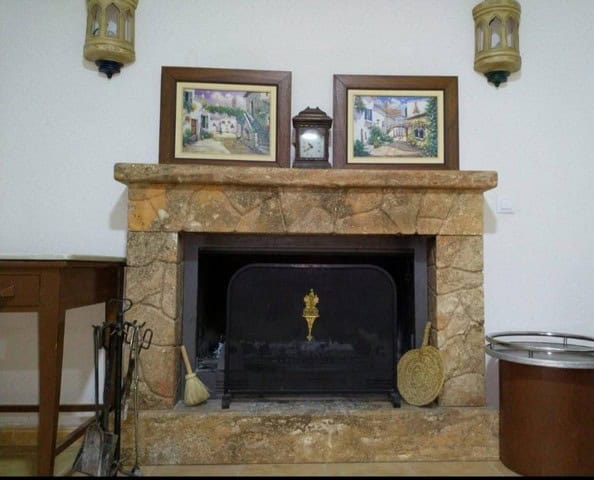 Charming fireplace in a rural property in Purchena, Almeria, with traditional decor and artwork.