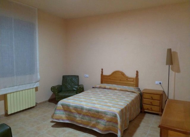 Charming rural property bedroom in Purchena, Almeria with simple furnishings and cozy atmosphere.