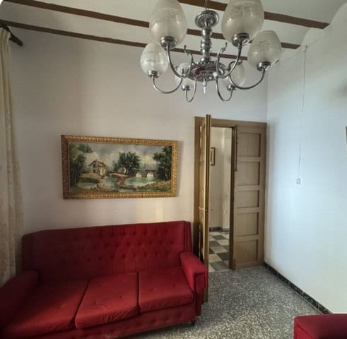 Interior view of a town house in Purchena, Almeria, featuring a red sofa and classic decor.