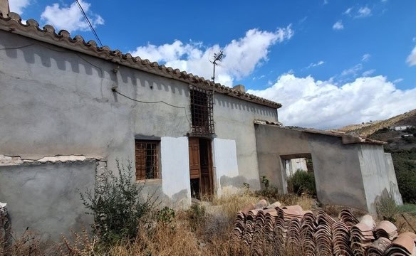 Rural property in Albox, Almeria, featuring a rustic house with tiled roof and scenic mountain views.