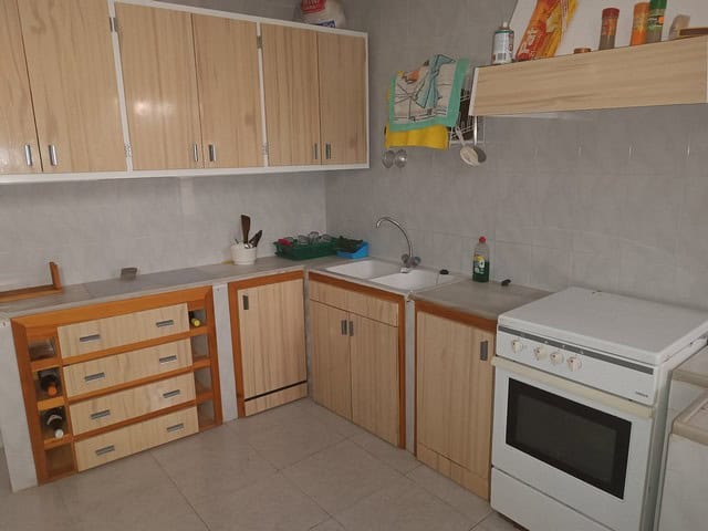 Kitchen with wooden cabinets and modern appliances in Caniles, Granada.