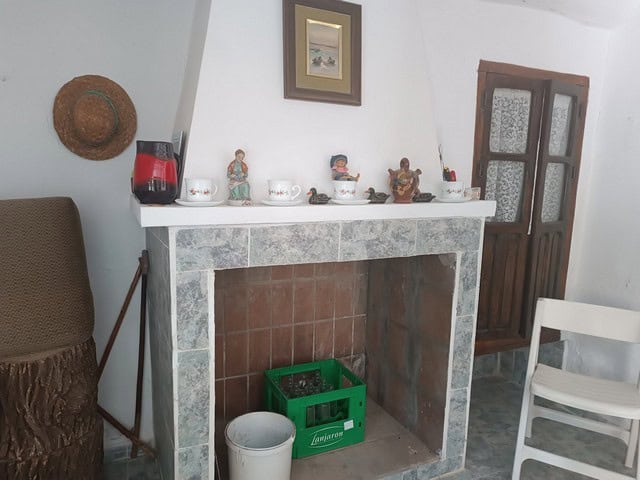 Fireplace with decorative items in a rural Caniles home.