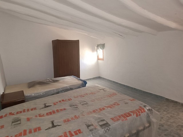 Cozy bedroom in a traditional rural property located in Caniles, Granada, featuring rustic white wal.