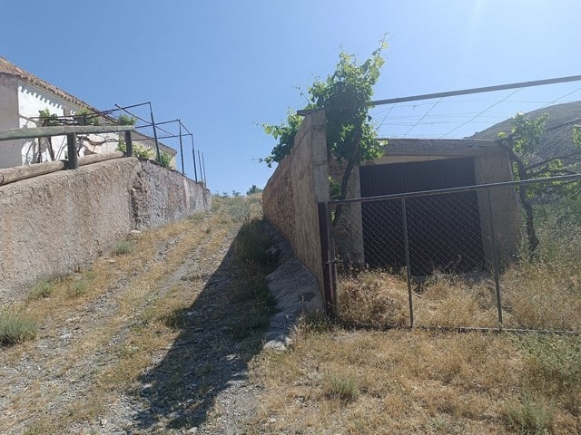 Rural property for sale in Caniles, Granada, featuring a rustic house with outdoor space and scenic.