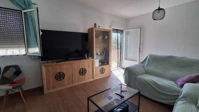 Bright living room with large windows and a cozy sofa in a villa in Armuna, Almeria.