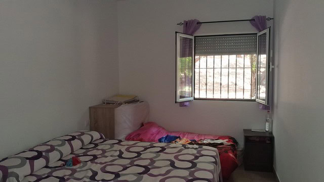 Cozy bedroom in a villa located in Armuna, Almeria, with a window overlooking the outdoors.