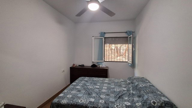 Bright bedroom with window and ceiling fan in Armuna, Almeria.