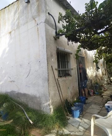 Traditional rural house exterior in Seron, Almeria, with weathered white walls and garden tools outs.