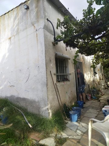 Traditional rural house exterior in Seron, Almeria, with weathered white walls and garden tools outs.