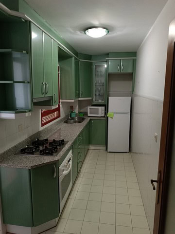 Bright kitchen with green cabinets in Seron, Almeria apartment.