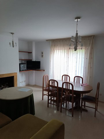 Cozy apartment interior in Seron, Almeria, featuring a dining area with wooden table and chairs. Bri.