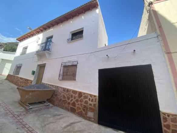 Town house with white exterior walls and a garage in Purchena, Almeria, Spain.
