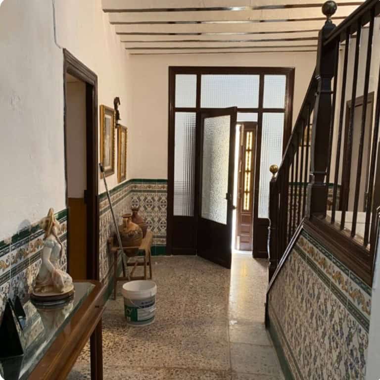 Traditional town house entrance with decorative tiles and wooden door in Purchena, Almeria.
