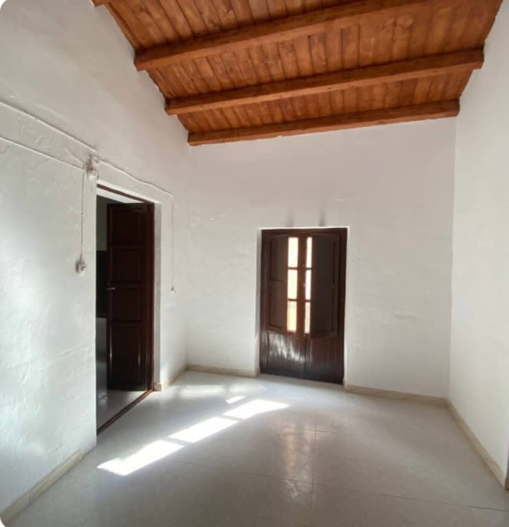 Charming interior of a town house in Purchena, Almeria with white walls and wooden ceiling.