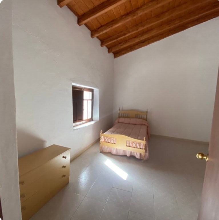 Cozy bedroom in a traditional town house in Purchena, Almeria with wooden ceiling and natural light.