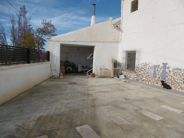 Cave house with white exterior walls and garage in El Margen, Granada, Spain.
