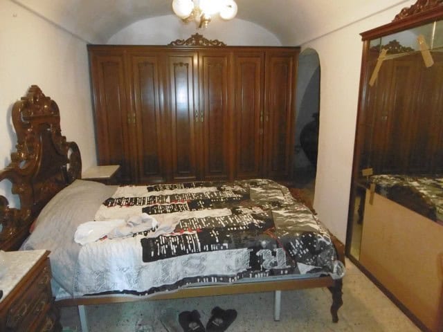 Charming cave house in El Margen, Granada, featuring traditional wooden furniture and rustic decor.