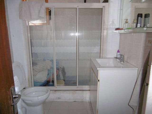 Traditional cave house bathroom in El Margen, Granada, featuring a shower, toilet, and sink.