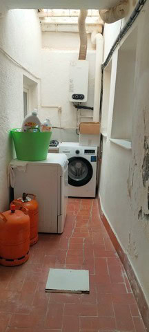 Charming laundry area in a traditional town house in Purchena, Almeria, featuring laundry appliances.