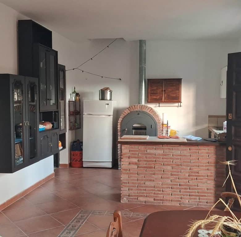 Charming rural property interior in Freila, Granada, featuring a cozy living space with a brick oven.