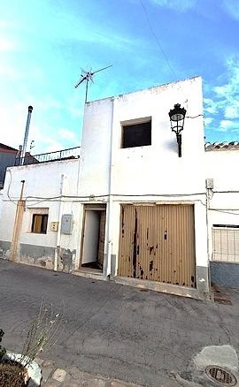 Traditional village house in Armuna, Almeria with a garage and outdoor lighting.