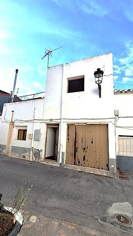 Traditional village house in Armuna, Almeria with a garage and outdoor lighting.