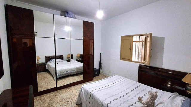Bright bedroom with a large wardrobe and window in a village home in Armuna, Almeria.