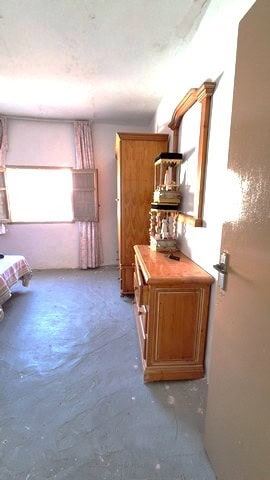Interior view of a village property in Armuna, Almeria, featuring simple furnishings and natural lig.