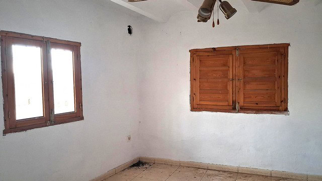 Interior view of a rural property in Albox, Almeria with white walls and wooden window shutters.