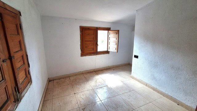 Interior view of a rural property in Albox, Almeria, with white walls and wooden window shutters.
