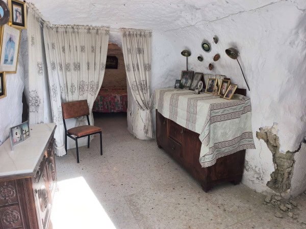 Charming cave house interior in Baza, Granada, featuring rustic decor and vintage furnishings.