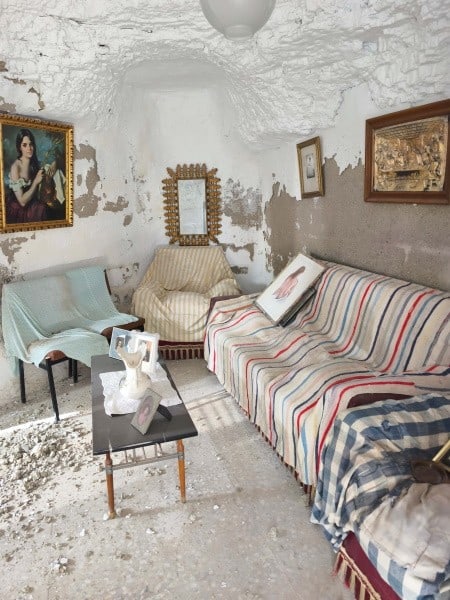 Cozy cave house living room with vintage furniture and artwork in Baza, Granada. Unique underground.