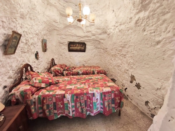 Unique cave house interior in Baza, Granada, with rustic stone walls and vintage decor.