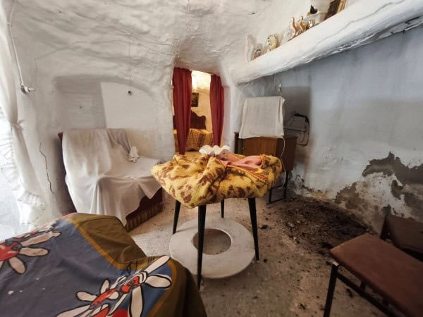 Interior of a traditional cave house in Baza, Granada, showcasing rustic furnishings and unique cave.