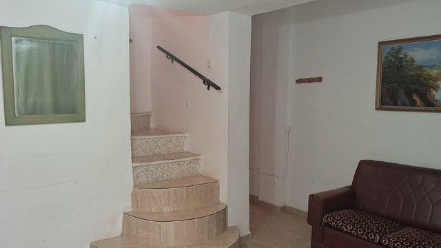 Bright interior of a village property in Seron, Almeria with staircase and cozy living area.