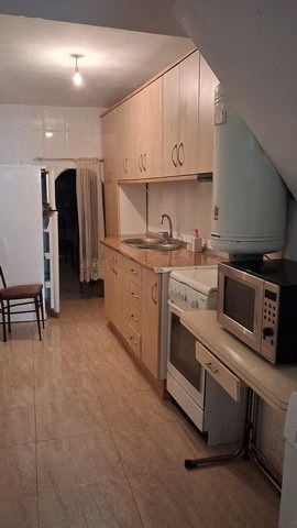 Charming kitchen in a village property in Seron, Almeria, featuring wooden cabinets, basic appliance.